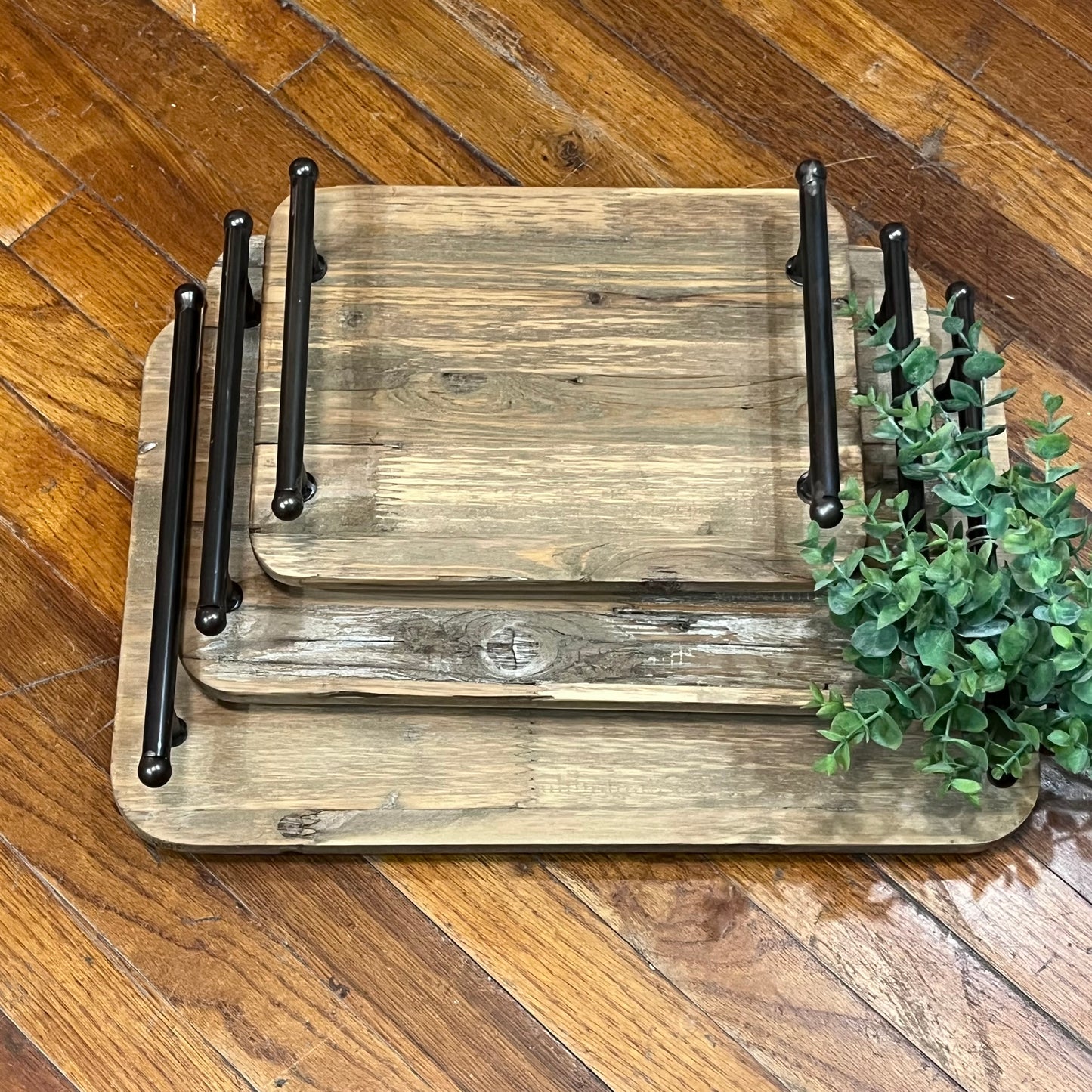 Set of wooden trays with metal stands on a wooden floor