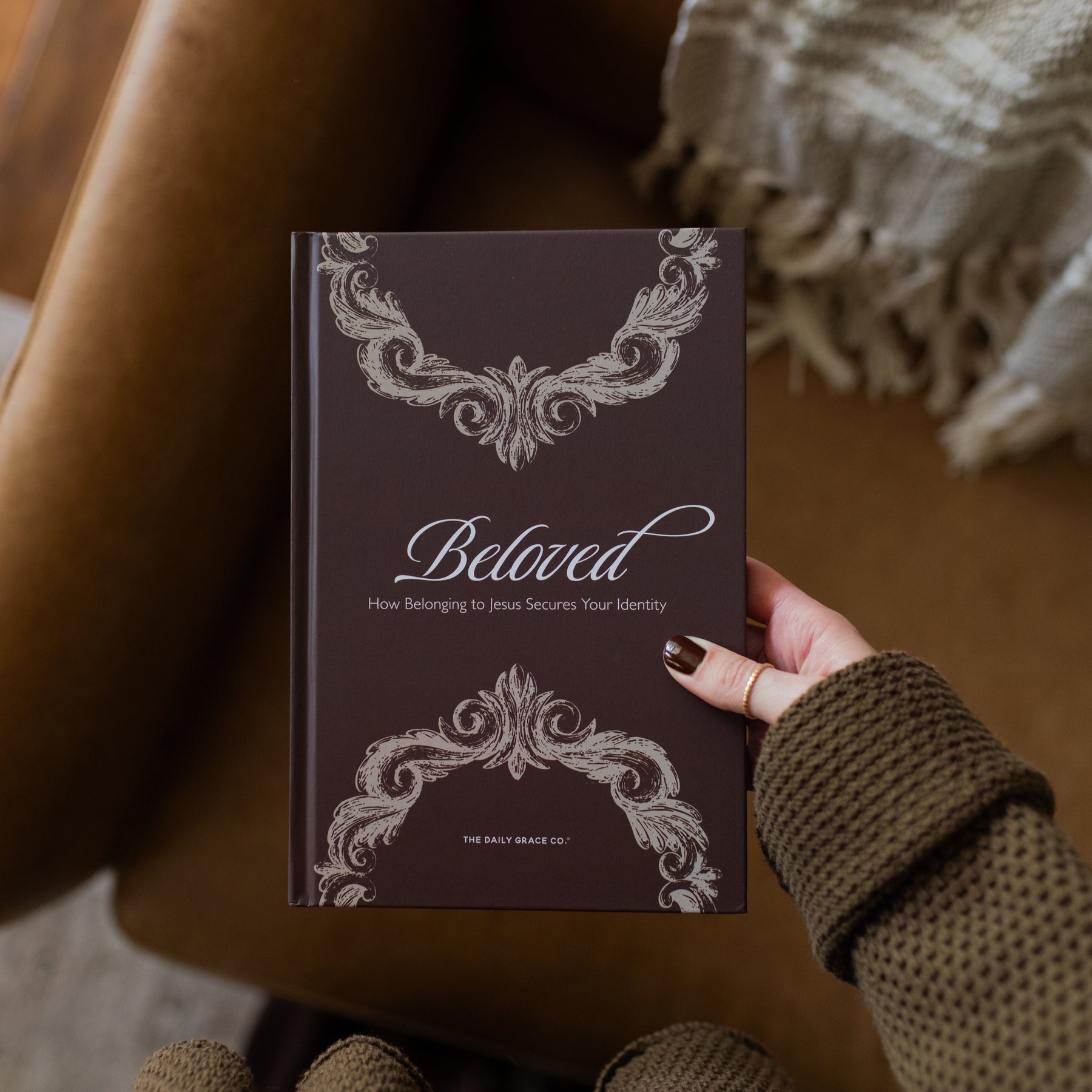 Book titled 'Beloved' held by a person with decorative cover design.